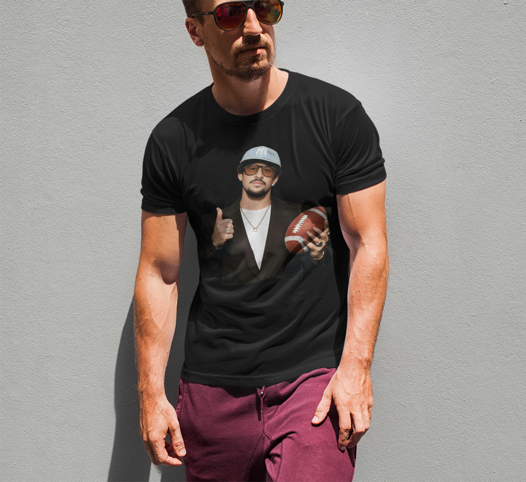 Man wearing a black t-shirt with a graphic of another man holding a football against a gray background